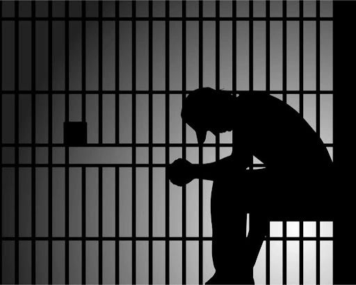 silhouette sitting in Arvada Jail Cell behind Bars in Colorado