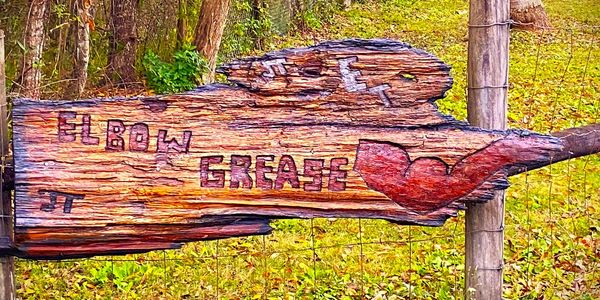 Driftwood we carried home on our Kayaks and carved into our business sign!