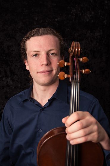 Young man holding a viola with a confident expression.
