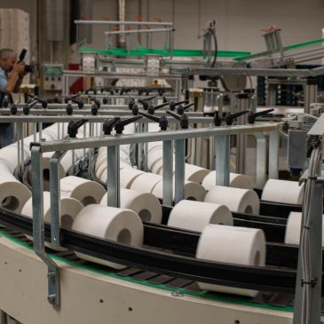 Factory machine handling rolls of paper.