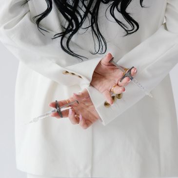 Hands in white suit sleeves chained with small scissors.