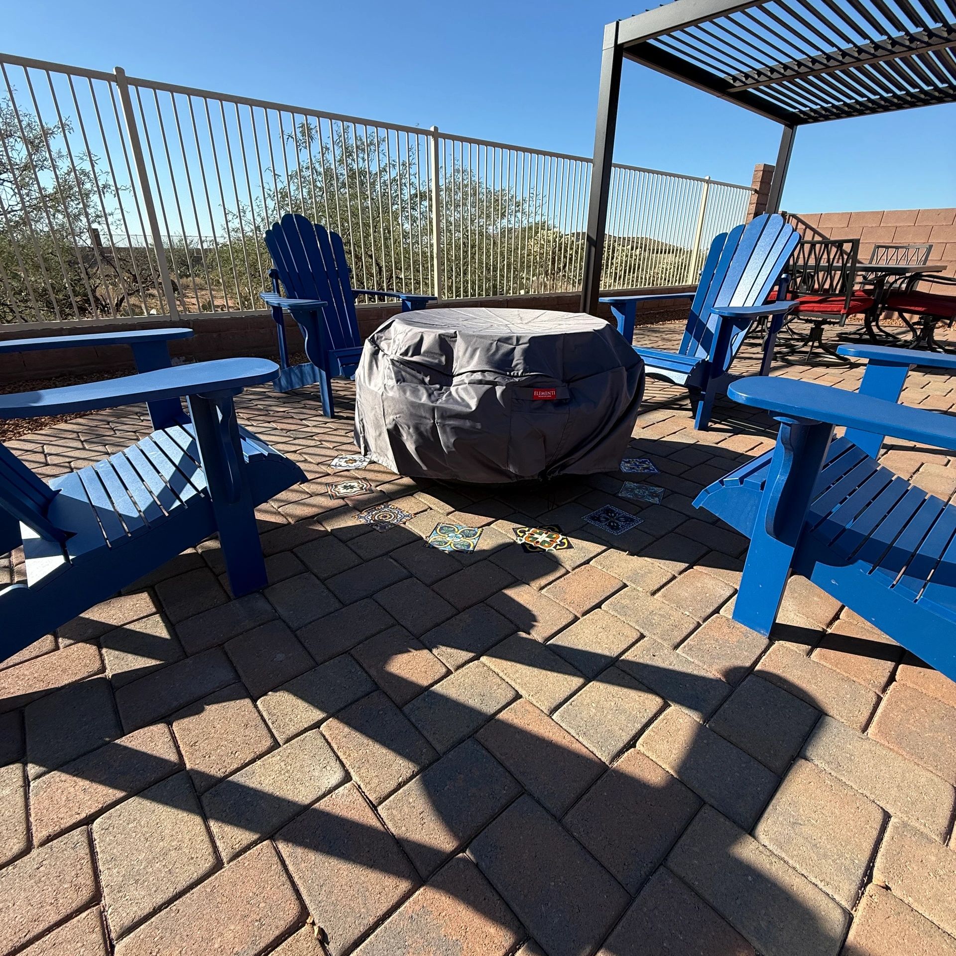 Patio pavers with a pergola and custom tiles integrated into the pavers