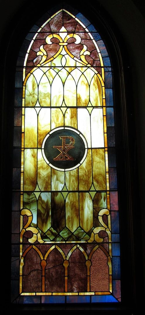 A stained glass window with religious symbols and intricate design.