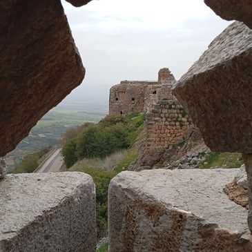 View of ancient stone ruins framed by a rocky window opening.