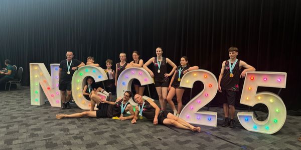 Group celebrating with light-up letters and medals.