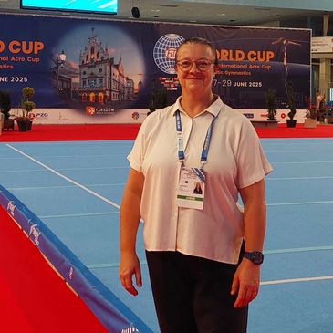Woman standing on a blue gymnastics floor at the World Cup event.