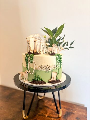 Garden themed 60th birthday cake with labradoodle figures.