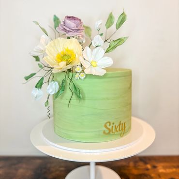 Green marbled cake with spring inspired wafer paper flowers.