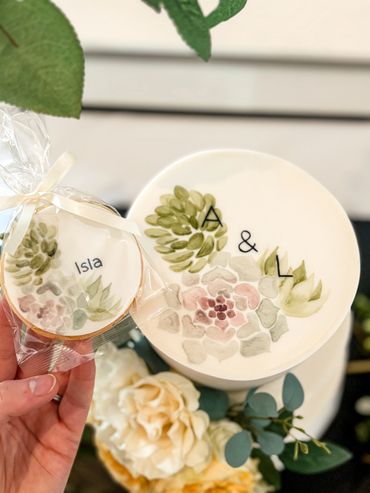 Hand painted biscuits with succulents and personalised names. Hand painted cake monogram to match.