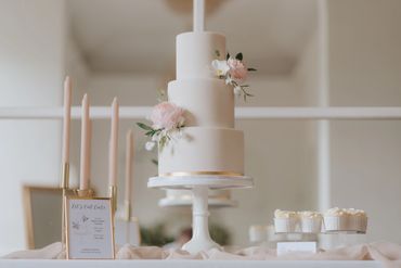 White 3 tier wedding cake with gold leaf and summer inspired sugar flowers in pastel pinks and white