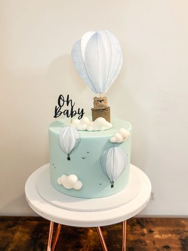 Hot air balloon and bear themed baby shower cake in blue.