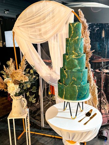 5 tier wedding cake in emerald green and gold textured marble.
