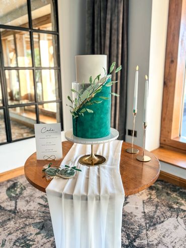 3 tier wedding cake with clear spacer, in emerald green and white with gold leaf and textural leaves
