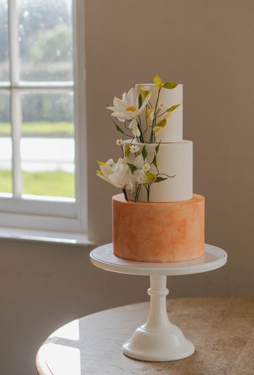 Side view of 3 tier cake with peach watercolour and sugar flowers