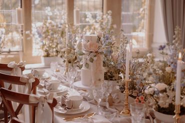 3 tier white cake with sugar flower display, sat amongst a country garden flower display table.