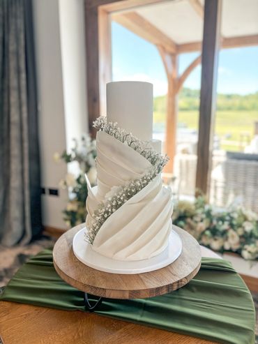 3 tier white wedding cake with sugar paste pleats and sugar gypsophila.