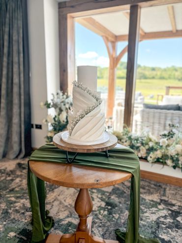 3 tier white wedding cake with sugar paste pleats and sugar gypsophila.