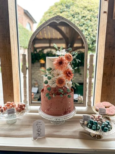 3 tier cake and dessert table. Rust and white cake with sugar flower display. 