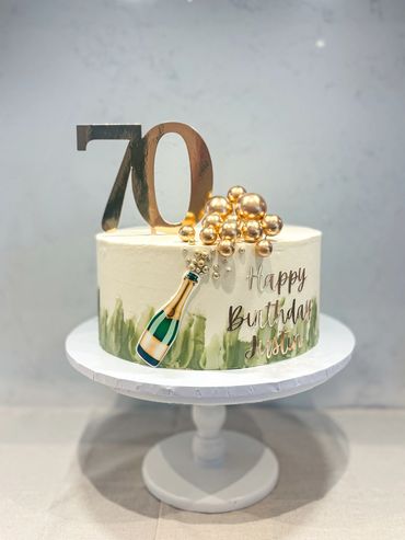 70th birthday cake with sage abstract details and champagne ‘pop’ design.