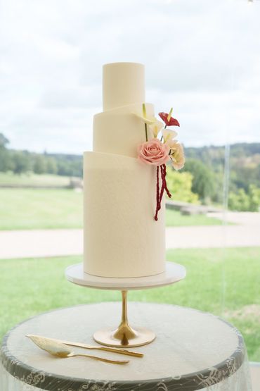 3 tier white wedding cake, embossed lace details and deep red and pink sugar florals 