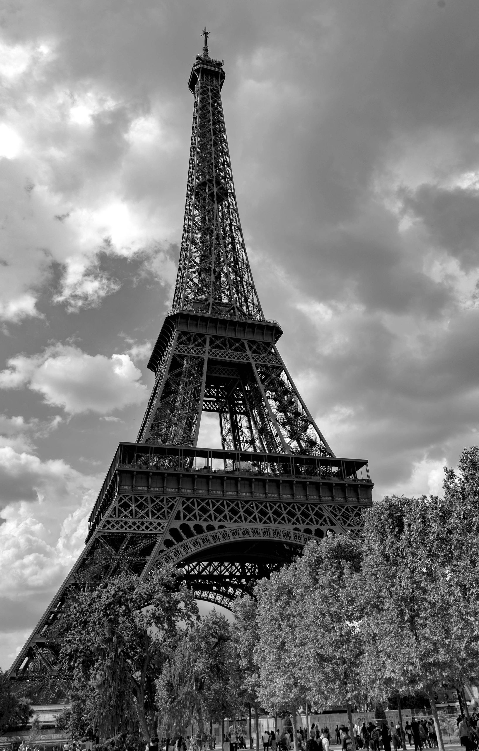 Black and white photo of the Eiffel Tower with clouds.