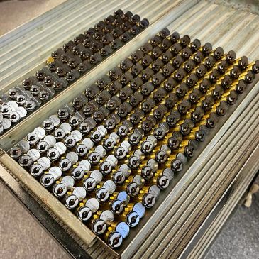 Rows of metal pins on a striped metal surface.