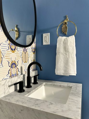 Modern bathroom sink with marble countertop and blue walls.