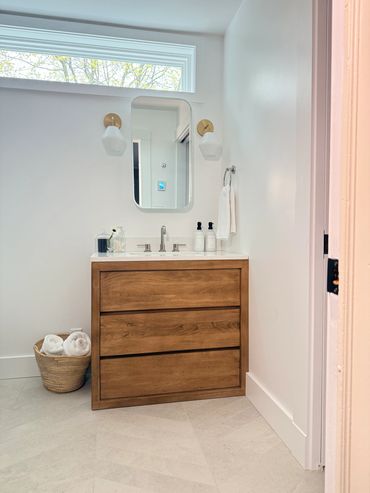 Modern bathroom vanity with wooden drawers and minimalistic decor.