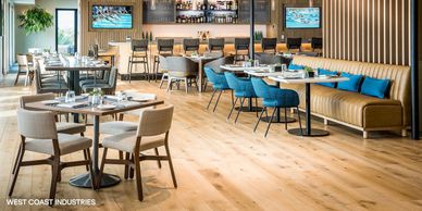 Modern restaurant interior with wooden floors and blue chairs.