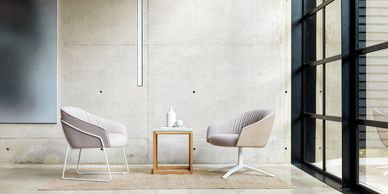 Modern seating area with two chairs and a small table.