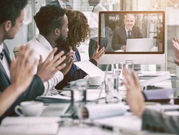 people in meeting with video conference equipment 
