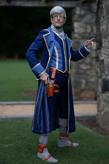 Regency style (original lore) Percy de Rolo cosplay from Critical Role, standing in a garden