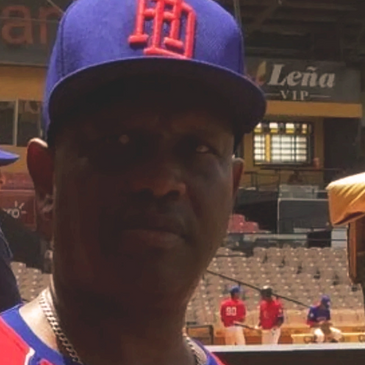 Man wearing a blue baseball cap in a stadium.