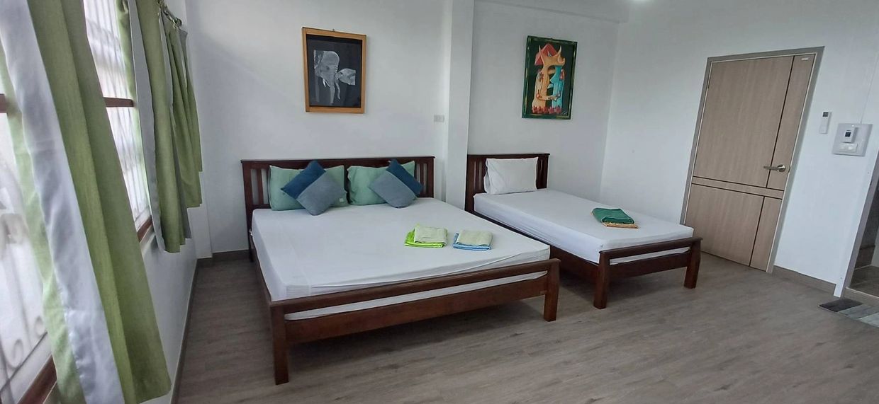 Clean bedroom with two beds and green accents.