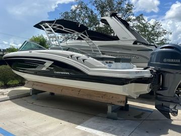 White and black Chaparral motorboat docked on land.
