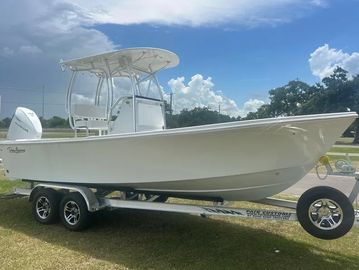 White boat on trailer under a blue sky.