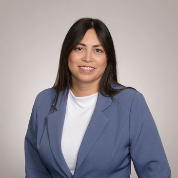 Professional woman in a blue blazer smiling confidently.