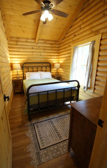 Queen bed with two night stands, two lamps, and dresser.