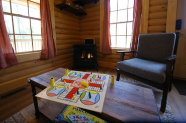 Living room chair, gas fireplace, and board game setup on coffee table.