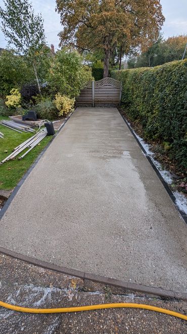 Freshly poured concrete driveway in a garden.
