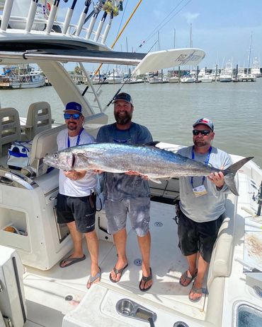 Three men holding a large fish