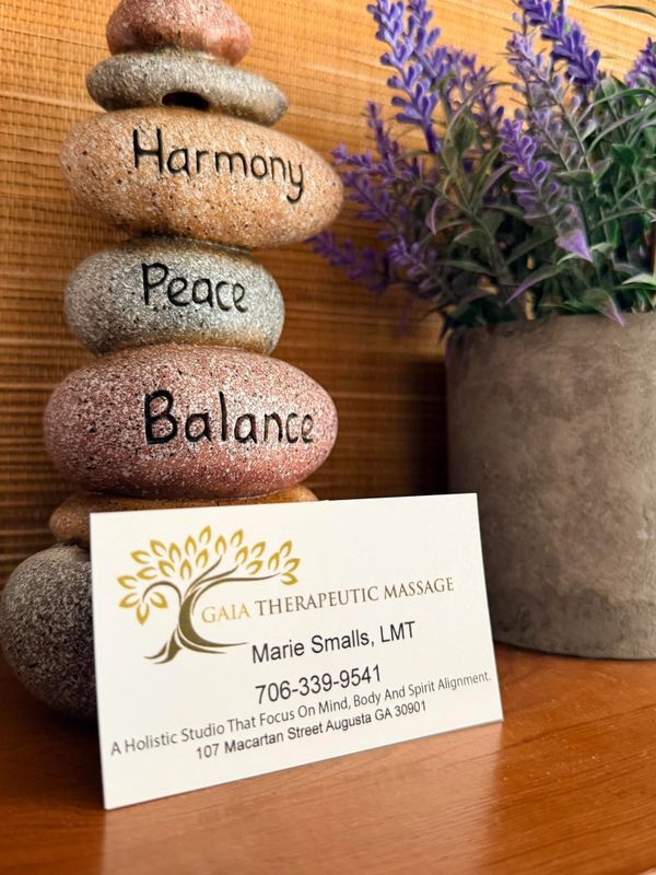 Stacked stones with words and a massage therapist's business card.