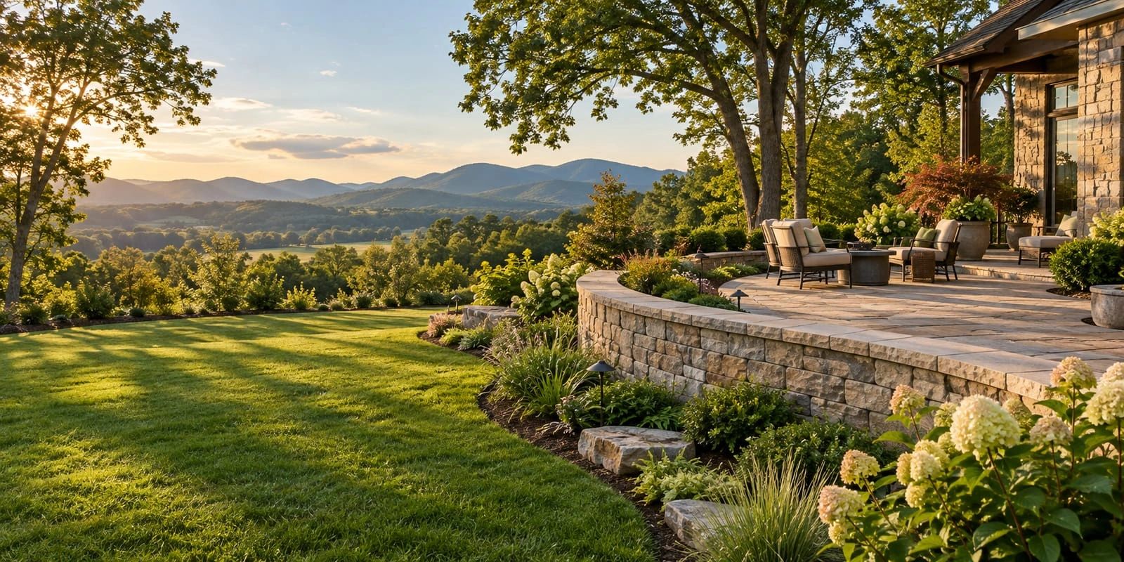 paver patio, curved stone wall and green lawn overlooking wooded hills