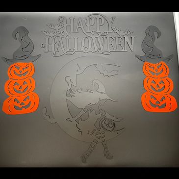 Halloween-themed window decal with witches, pumpkins, and greeting.
