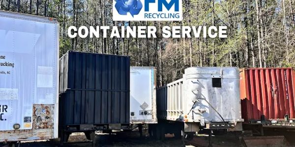 Various large recycling containers lined up outdoors.
