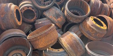 Pile of rusty old metal wheel rims.