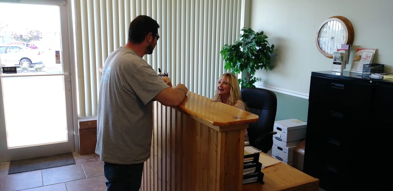 Lorie assisting a patient with paperwork.