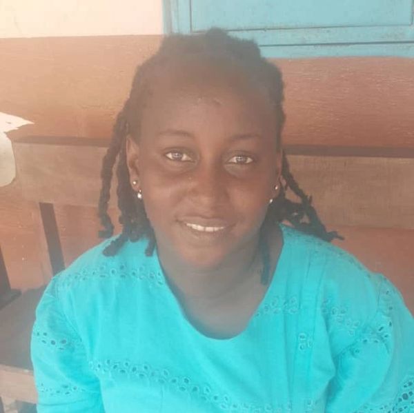 Woman in turquoise top smiling at camera.
