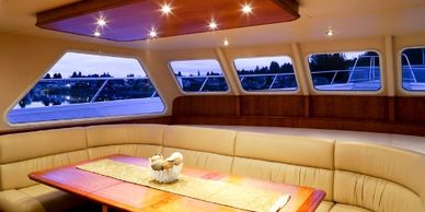 Luxurious yacht interior with cozy seating and wooden table.