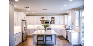 Bright modern kitchen with white cabinetry and central island.